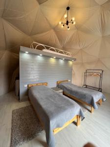 two beds in a yurt with a ceiling at GLAXY_GLAMPING in Karakol