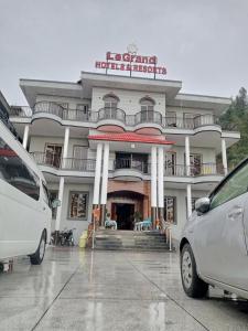 two cars parked in front of a building at LeGrand Hotel & Resort in Swat