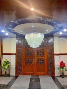 a large wooden door with a chandelier above it at LeGrand Hotel & Resort in Swat