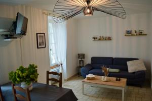 ein Wohnzimmer mit einem blauen Sofa und einem Tisch in der Unterkunft duplex nouvelle du gué in Pouilly-en-Auxois