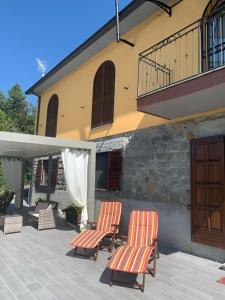 2 sillas en un patio frente a una casa en Ca' Degli Olivi. Relax Lunigiana, en Agnino