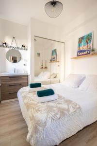 a white bedroom with a large bed and a sink at Escapade à Sanary au Cœur du Village in Sanary-sur-Mer