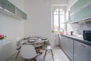 eine kleine Küche mit einem Tisch und 2 Stühlen in der Unterkunft MONZA centro-Milano [Casa di Fronte alla Stazione] in Monza