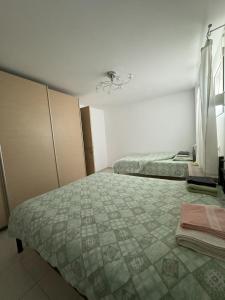 una camera con due letti e un lampadario a braccio di Antoaneta's apartment a Kalamítsi