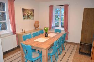 a dining room with a wooden table and blue chairs at Alte Schule in Neu Wendischthun