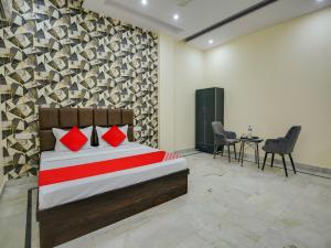 a bedroom with a bed and a table and chairs at OYO Hotel Orchid Regency in Ludhiana