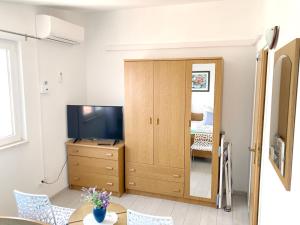 a living room with a television and a wooden cabinet at Levanda in Trogir
