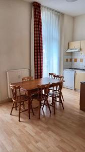 - une salle à manger avec une table et des chaises en bois dans l'établissement Résidence Les Iles Britanniques, à La Bourboule