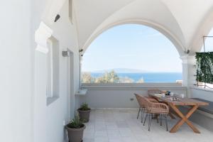 a patio with a table and chairs and a window at Central Hostel Oia in Oia