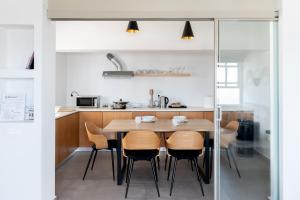 a kitchen with a wooden table and chairs at Central Hostel Oia in Oia