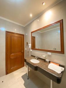 a bathroom with a sink and a large mirror at Status Hotel in Río Grande