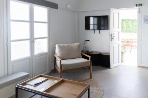 a living room with a chair and a table at Central Hostel Oia in Oia