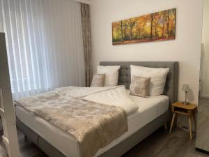 a bed in a bedroom with a painting on the wall at Modernes Apartment mit Whirlpool & Gartensauna in Geisenheim