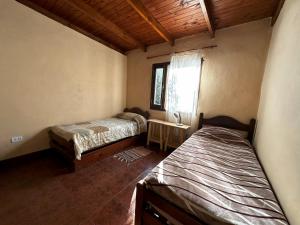 um quarto com duas camas e uma janela. em Los ciruelos - Casas de Motaña em Tafí del Valle