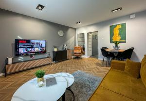a living room with a tv and a table at Apartamenty Zielona in Uniejow