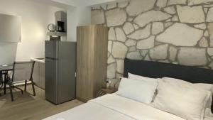 a bedroom with a stone wall behind a bed at Afytos sea view in Afitos +59 photos