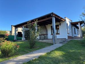une petite maison blanche avec un auvent sur une cour dans l'établissement Los ciruelos - Casas de Motaña, à Tafí del Valle