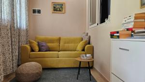 a living room with a yellow couch and a table at Apartment Dulcis Domus in Bale