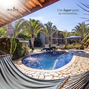 a hammock in front of a house with a swimming pool at Unalome Pousada in Serra Negra