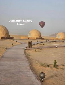 un globo de aire caliente volando sobre un desierto con domos en Julia Rum Luxury Camp, en Wadi Rum