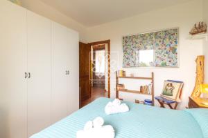 1 dormitorio con 1 cama con 2 toallas en Casa Maria Grazia, en Stintino