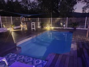 una piscina por la noche con terraza de madera en Spa Ibiza Dosrius, en Canyamars