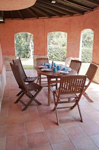 einen Holztisch und Stühle auf einer Terrasse in der Unterkunft Villa Caposchiera Indipendente in Torre delle Stelle