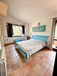 ein Schlafzimmer mit einem blauen Bett in einem Zimmer in der Unterkunft Villa Caposchiera Indipendente in Torre delle Stelle
