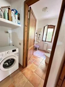 ein Badezimmer mit einer Waschmaschine und einem WC in der Unterkunft Villa Caposchiera Indipendente in Torre delle Stelle