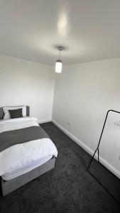 a bedroom with a bed and a white wall at San Pedro- Flotilla Lodge in Chatham
