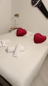 a white bed with two red pillows on it at Calatafimi Rocca Home in Palermo