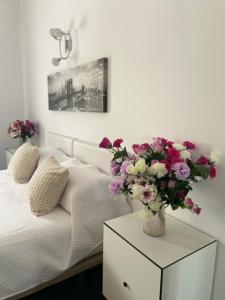 een slaapkamer met een bed met een vaas met bloemen op een tafel bij The Dragonfly Retreat in Málaga