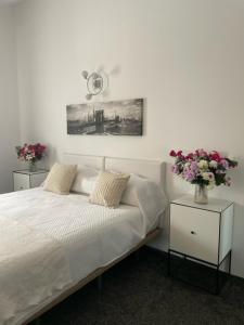 een slaapkamer met een bed en 2 tafels met bloemen bij The Dragonfly Retreat in Málaga