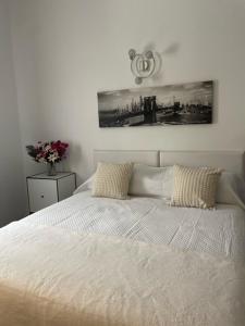 een wit bed met 2 kussens in een slaapkamer bij The Dragonfly Retreat in Málaga
