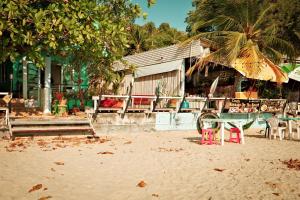 een strand met stoelen en een gebouw op het strand bij Sea Dreamer Beachfront Apartments in Phuket