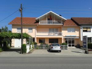 a house with a car parked in front of it at Apartman River in Prijedor