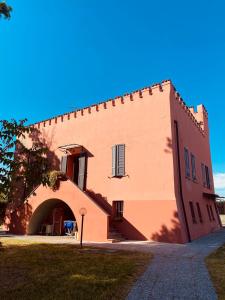 een groot bakstenen gebouw met een boog in een tuin bij B&B Al Castello Sweethome in Parma