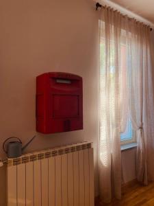 una caja roja en la pared junto a una ventana en B&B Al Castello Sweethome en Parma