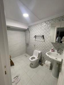 a bathroom with a toilet and a sink at منتجع ريف خزيمة - الياسمين in Al Madinah