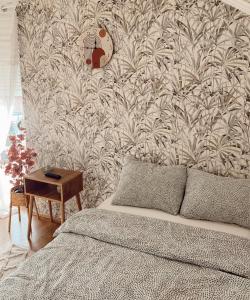 een slaapkamer met een bed en een muur met behang bij Cozy House in Lazarevac