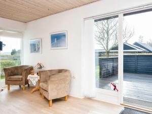 een woonkamer met 2 stoelen en een glazen schuifdeur bij 6 person holiday home in B rkop in Børkop