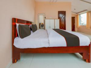 - une chambre dotée d'un grand lit avec des draps et des oreillers blancs dans l'établissement OYO ARKA RESORTS VENUE OF JOY, à Pedda Ambarpet