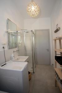 een badkamer met een wastafel, een douche en een spiegel bij Marco Polo 30 in Porto Recanati