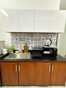 a kitchen with a sink and a microwave at Calmette Home in Ho Chi Minh City