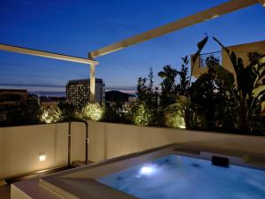 a bath tub sitting on top of a balcony at night at Bond Smart Living Suites in Athens