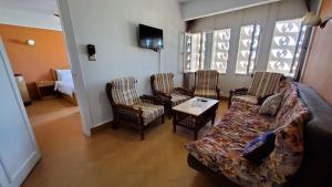 Una sala de estar con un sofá y sillas y una mesa. en Adriatica Hotel Marsa Matrouh, en Marsa Matruh