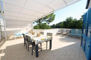 a table and chairs on a patio with a white canopy at Marco Polo 30 in Porto Recanati