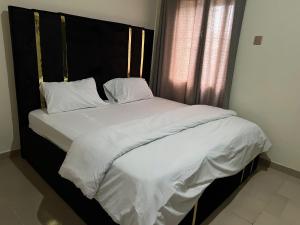a large bed with white sheets and pillows at YP-Made Luxurious 1 & 2 Bedroom Apartments in Eluju