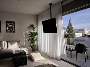 a living room with a couch and a large window at Bond Smart Living Suites in Athens