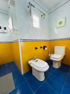 een gele badkamer met een toilet en een wastafel bij Sweet Atic in Sitges